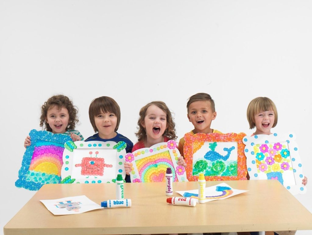 a picture with a group of children having created various artworks with their dot makers pens.